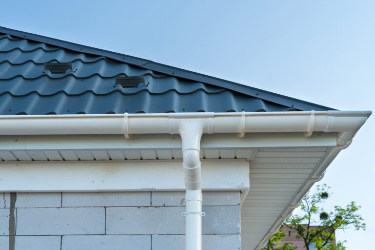 New metal tile roof with white rain gutter
